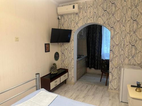 una camera da letto con un letto e una TV a parete di BABhome a Kutaisi