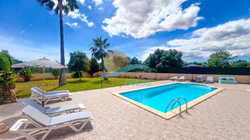 a swimming pool with two lounge chairs next to a swimming pool at Villa Pedro by Sunny Deluxe in Albufeira