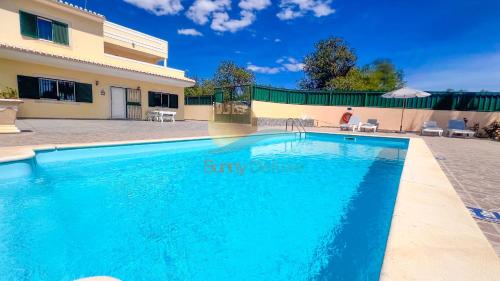 a swimming pool in front of a house at Villa Pedro by Sunny Deluxe in Albufeira
