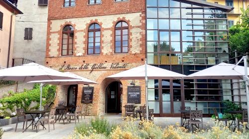 a restaurant with tables and umbrellas in front of a building at Casa Svizzera Agriturismo in Barolo