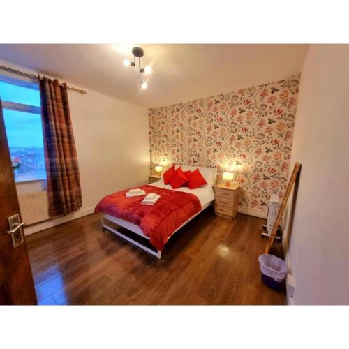 a bedroom with a bed with red pillows and a window at Stylish 1 Bed Flat in the Heart of Marble Arch in London