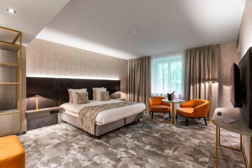 una habitación de hotel con una cama y un televisor en Van der Valk Waterloo, en Waterloo