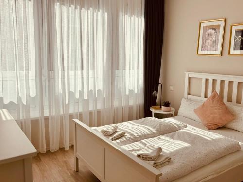 Schlafzimmer mit einem Bett und einem großen Fenster in der Unterkunft Gemütlich & zentral - Im Herzen von Braunschweig in Braunschweig