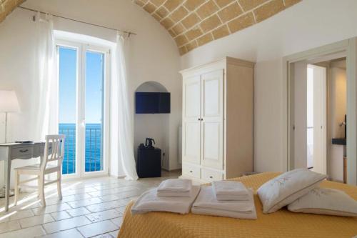 a bedroom with a bed and a desk and a window at B&B Finestra Sul Mare in Gallipoli