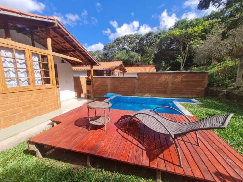 una terraza con una silla y una piscina en Chalés da Estrada Velha, en Tiradentes