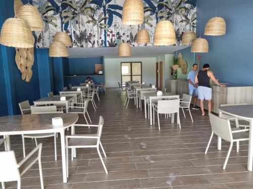 dos personas de pie en un restaurante con mesas y sillas en Ecoresort - Praia dos Carneiros, en Rio Formoso