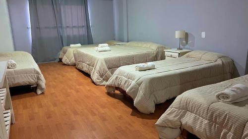 a room with three beds with towels on them at Hotel Los Angeles in Santa Teresita