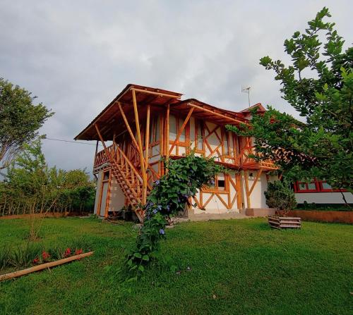 a house with a wooden structure in a yard at Casa Laureles in Filandia