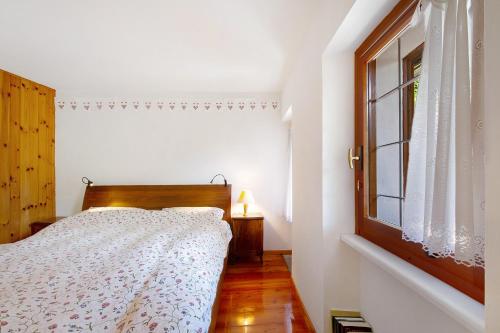 a white bedroom with a bed and a window at Casa Savin in Pontboset