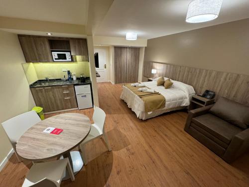Intersur Suites في بوينس آيرس: غرفة نوم بسرير وطاولة واريكة