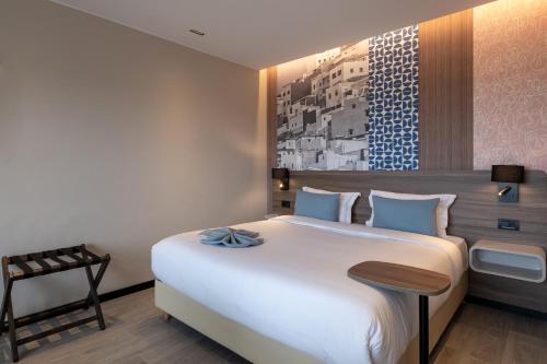 a bedroom with a large white bed in a room at Occidental Tanger in Tangier