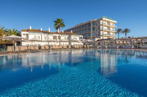 une grande piscine en face d'un bâtiment dans l'établissement Occidental Torremolinos Playa, à Torremolinos