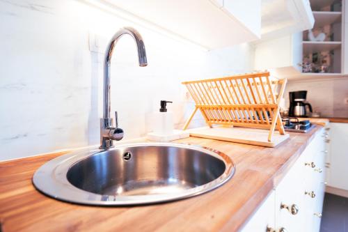 - un évier dans une cuisine avec un comptoir en bois dans l'établissement Lets Relax - Coté jardin, à Mons