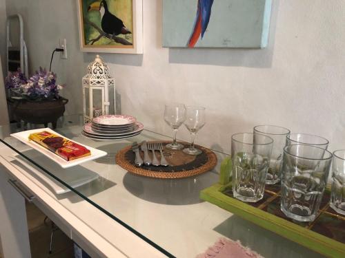 a table with glasses and a plate of food on it at Body & Mind Beautiful - Suites Elegantes e Charmosas in Franca