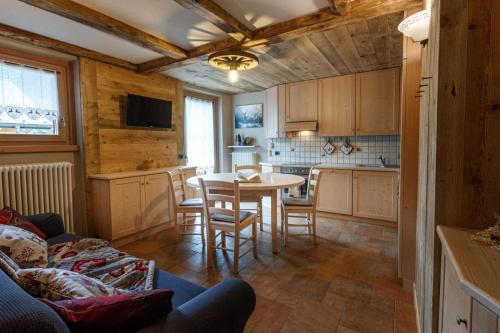 een keuken en eetkamer met een tafel en stoelen bij Casa Clus apartments Bormio 2 in Valdisotto