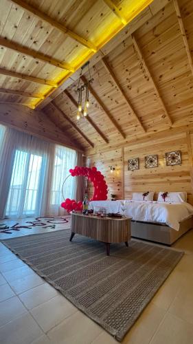 1 dormitorio con 1 cama grande y 1 mesa en درة العروس اكواخ الدره en Durat  Alarous