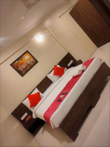 a bedroom with a large bed with red pillows at Kedari Residency in Yeraoda