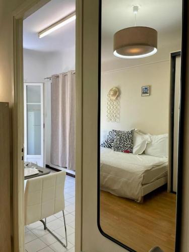 une chambre avec un lit et une pièce avec un miroir dans l'établissement Charmant F1 terrasse ombragée, au Cannet