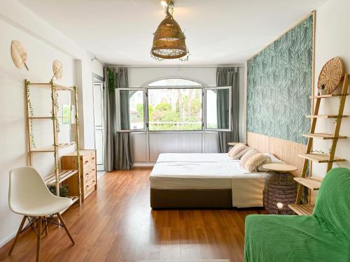 a bedroom with a bed and a chair and a window at Sherpa Apartments in Ayia Napa
