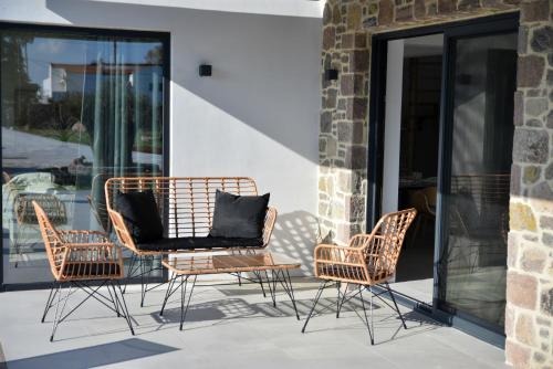 a group of chairs and a table on a patio at Kalloni Sunset Villas Lesvos in Skala Kallonis