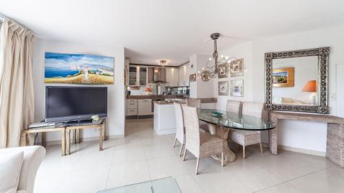 un salon avec une télévision et une salle à manger dans l'établissement Appartement Mandelieu sur les berges de Siagne, à Mandelieu-la-Napoule