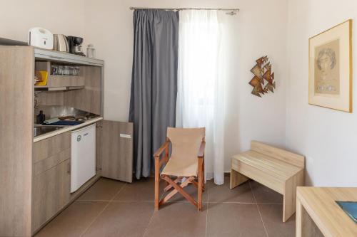 a kitchen with a table and a chair in a room at Oinoni's Home - AIAKOS in Souvala