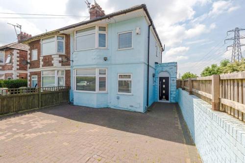 a blue house with a fence in front of it at Classic 4 Bedroom House in Wirral with WiFi & Parking Sleeps 9 by PureStay in Wirral