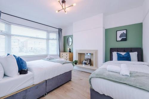 two beds in a bedroom with green walls at Classic 4 Bedroom House in Wirral with WiFi & Parking Sleeps 9 by PureStay in Wirral