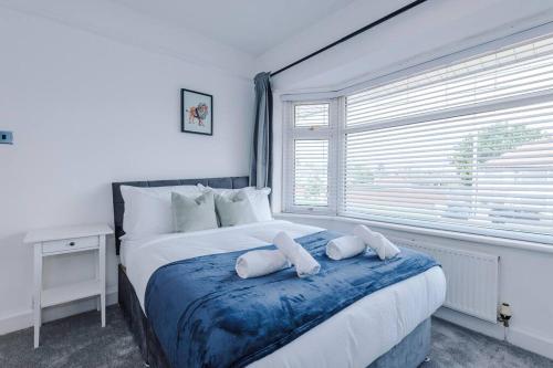 a bedroom with a large bed with two pillows on it at Classic 4 Bedroom House in Wirral with WiFi & Parking Sleeps 9 by PureStay in Wirral