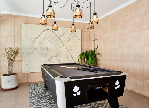 a pool table in a room with lights at Flacalco Hotel & Apartments in Cala Ratjada