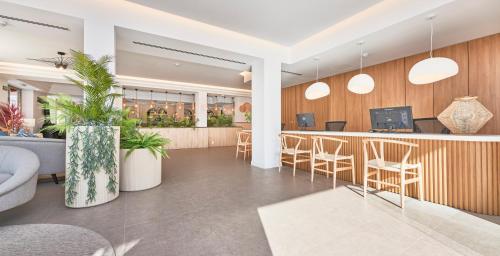 a lobby with a bar with stools at Flacalco Hotel & Apartments in Cala Ratjada