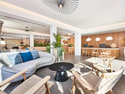 a living room with a couch and chairs and a table at Flacalco Hotel & Apartments in Cala Ratjada