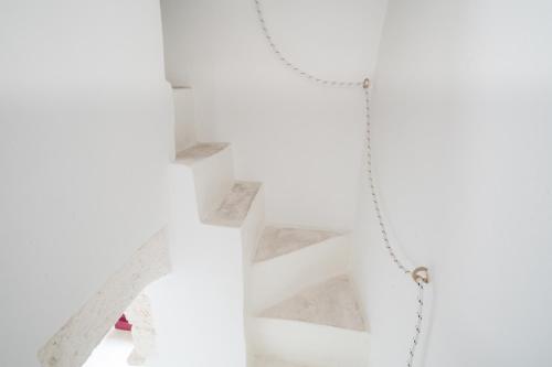 una scala in una stanza bianca con una catena di Casa La Stella - terrazza e vista sul mare a Ostuni
