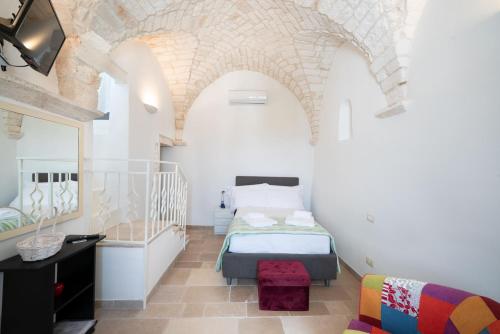 una camera da letto con un letto e una sedia in una stanza di Casa La Stella - terrazza e vista sul mare a Ostuni