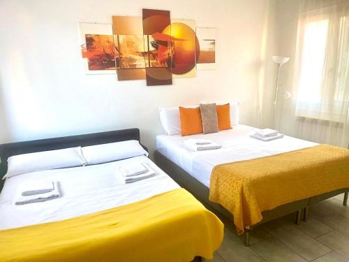twee bedden in een kamer met geel en wit bij 4-Tourist House Bologna-Studio - Self check-in in Bologna