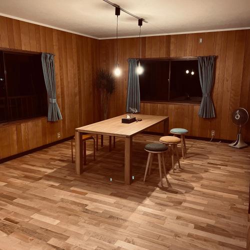 a dining room with a table and two stools at Mekiki出雲 in Izumo