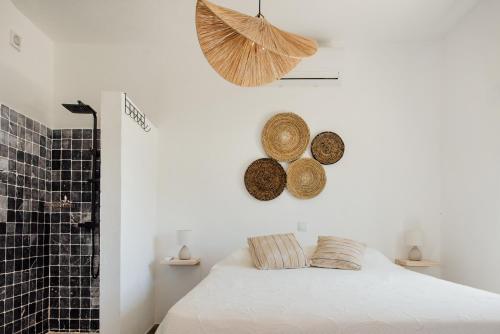 1 dormitorio con 1 cama y cestas en la pared en Gatehouse Entrecolinas, en Paderne