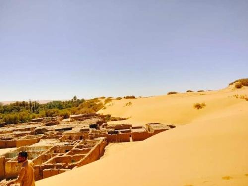 a man standing in the middle of a desert at الصحراء البيضاء in Bawiti