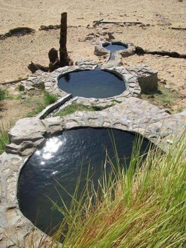 two pools of water in a stone structure on the beach at الصحراء البيضاء in Bawiti