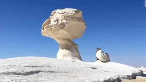 a group of rocks sitting on top of a mountain at الصحراء البيضاء in Bawiti