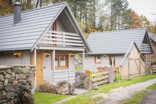 a small white house with a fence in front of it at Chata pod hradom 1 in Uhrovské Podhradie