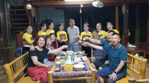 a group of people sitting around a table at Thao Ly Homestay Mai Chau in Hòa Bình
