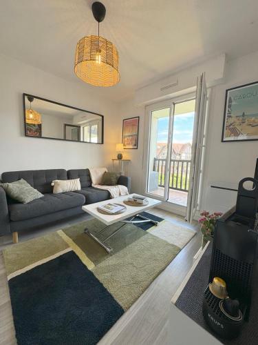 un salon avec un canapé et une table dans l'établissement Cabourg Plage 5, à Cabourg