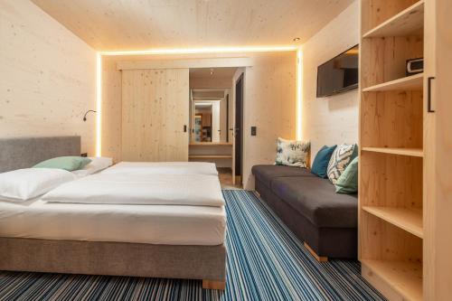 1 dormitorio con 1 cama y 1 sofá en Ferienalm Panorama Apartments en Schladming