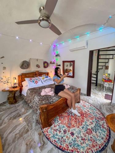 a woman sitting on a bed in a bedroom at La Bota del Gigante in Gigante