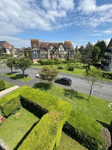 - une vue sur une maison avec une voiture dans une rue dans l'établissement Cabourg Plage 5, à Cabourg