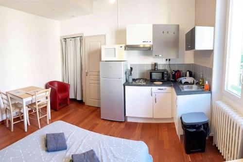 une cuisine avec un réfrigérateur blanc et une table dans l'établissement Studio CHAGALL, à Chambéry