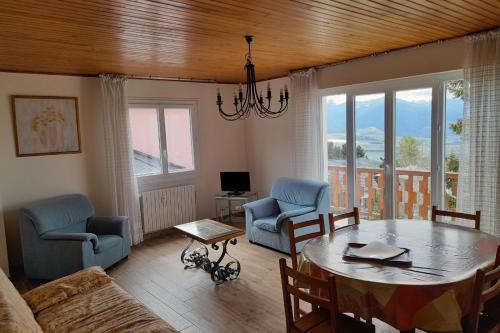 un salon avec une table et des chaises dans l'établissement Appartement Le Panoramic vue montagne à Font Romeu, à Font-Romeu-Odeillo-Via