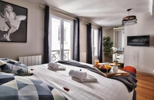 ein Schlafzimmer mit einem großen Bett und einem Tablett mit Essen darauf in der Unterkunft 833 - Charming studio in Paris Olympic Games 2024 in Paris