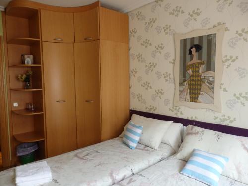 a bedroom with a bed with a wooden cabinet at Alojamientos Olga in Pamplona